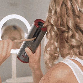 Woman using curler in front of mirror